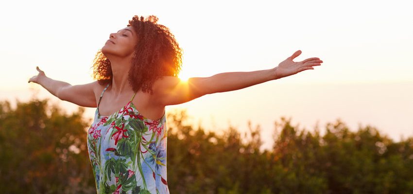 Linda mulher expressando a sua liberdade, ao ar livre, com os braos abertos