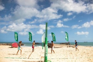 Pessoas jogando na quadra de volei e futevolei na praia no Poo da Draga