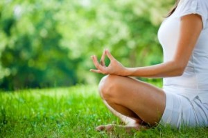 mulher relaxando na grama fazendo meditao