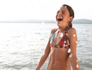 criana feliz na praia