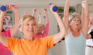 Senhoras praticando exercidos com halteres.