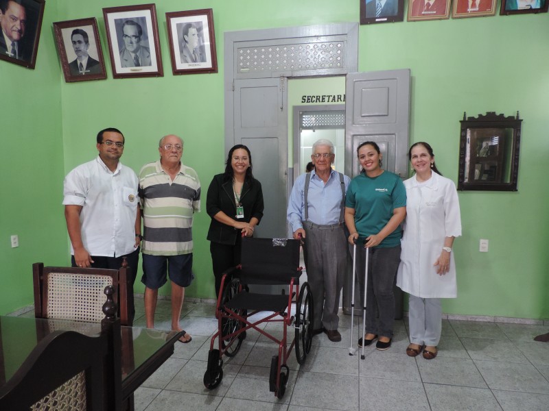 Colaboradores da Unimed Fortaleza entregando cadeira de rodas no Lar Torres de Melo.