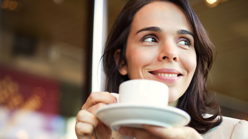 mulher tomando cafe feliz