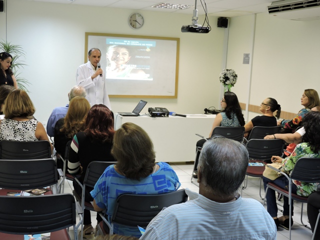 Mdico em p ministrando seminrio para clientes