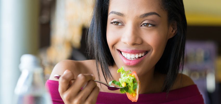 Jovem mulher comendo salada fresca