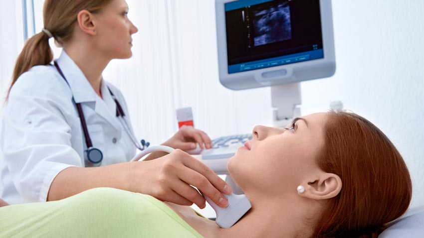 Médica com equipamento de ultrassom no pescoço de uma mulher