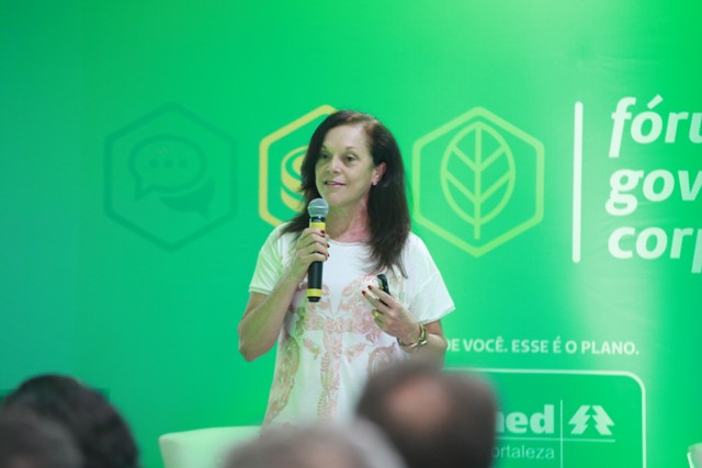 Uma das palestrantes do Fórum de Governança Corporativa com microfone na mão