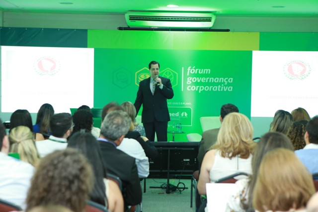 O gerente do núcleo de desenvolvimento humano, eventos e sustentabilidade da Unimed do Brasil, Maike Morn, com microfone na mão no palco