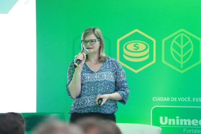 Uma das palestrantes do Fórum de Governança Corporativa com microfone na mão