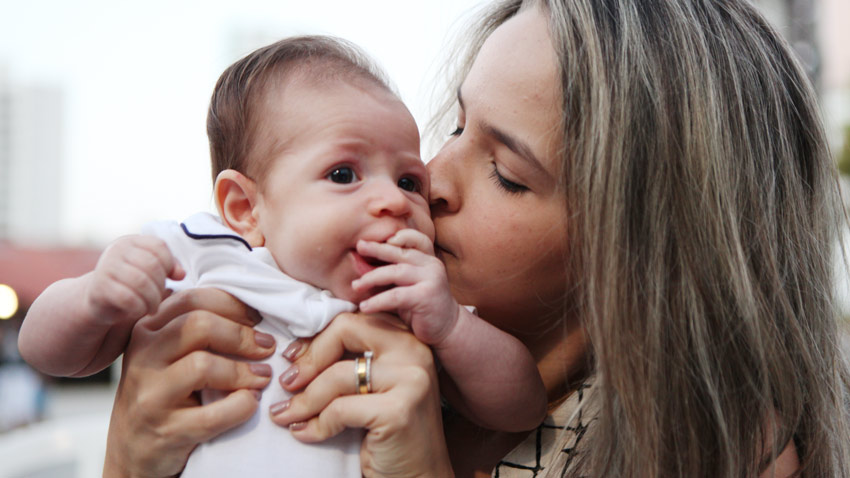Colaboradora Vivian Costa beijando seu filho no rosto
