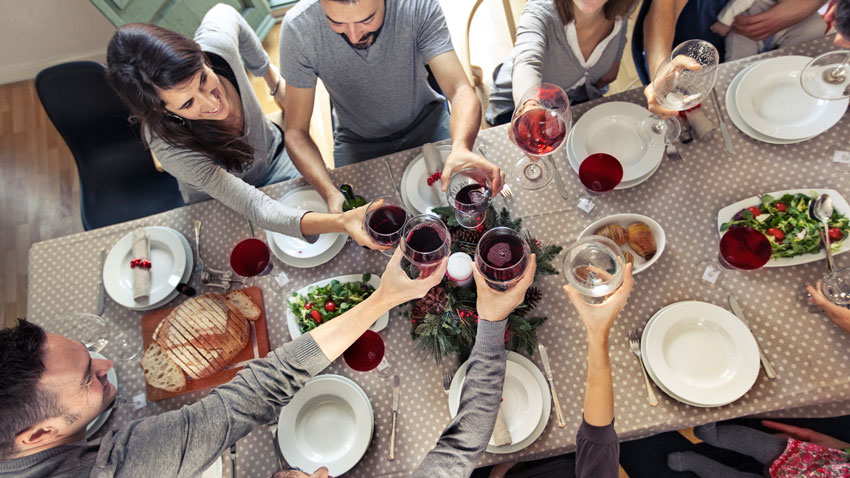 Vrios jovens reunidos em uma mesa brindando