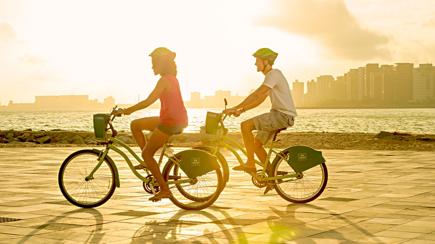 Casal andando de bicicleta na orla