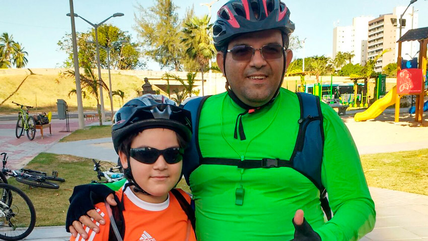 Cliente Helder Pontes e seu filho com roupas apropriadas para andar de bicicleta