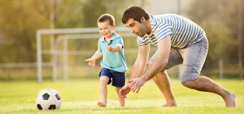 Pai e filho jogando futebol ao ar livre