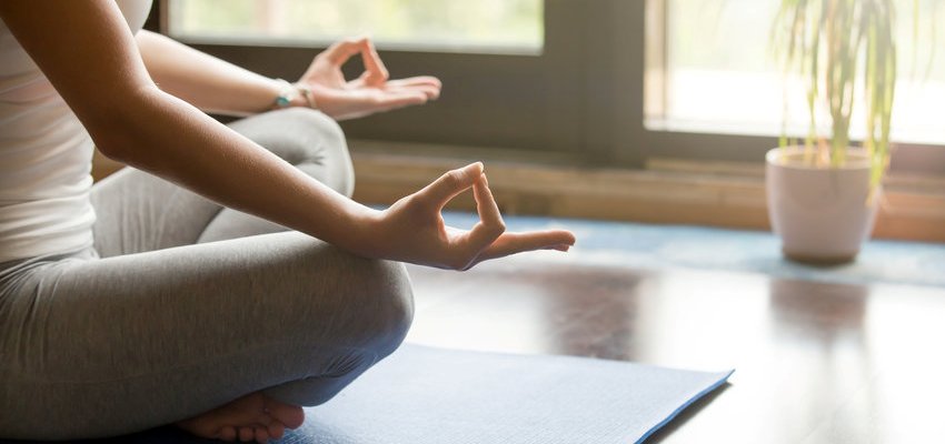 Mulher praticando ioga em um lugar tranquilo de casa