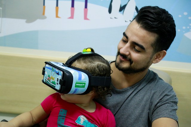 Pai com a filha experimentando o culos de realidade virtual