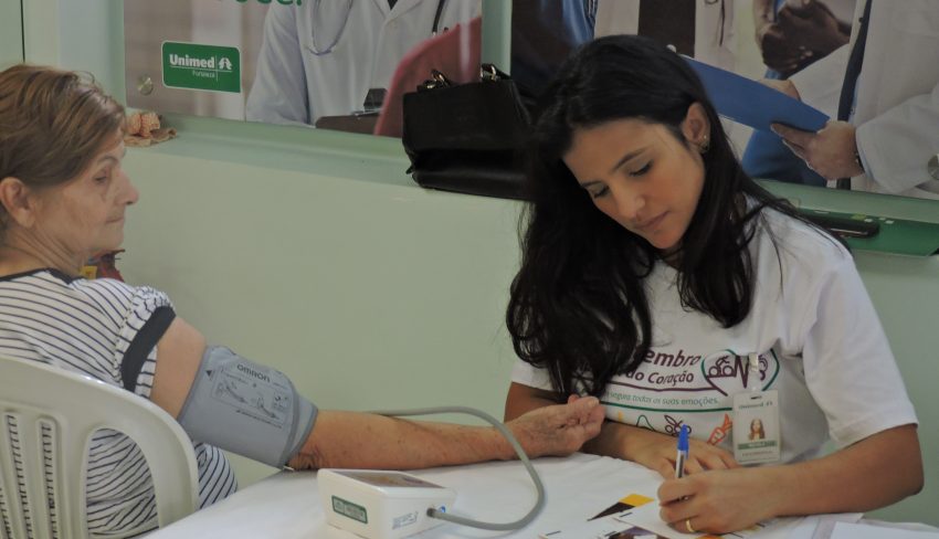 Idosa aferindo a pressão na ação do Dia Mundial do Coração