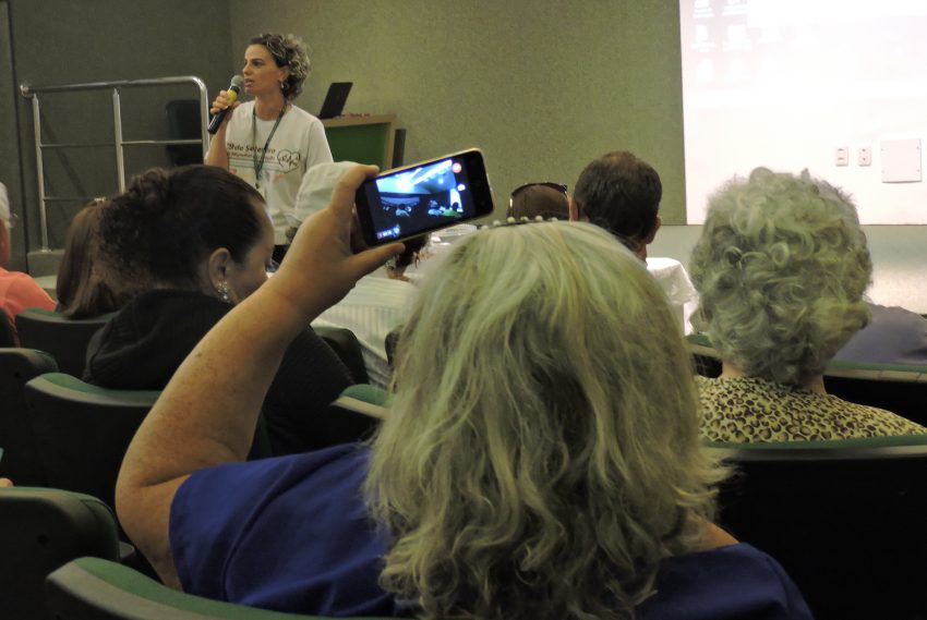 Participante filmando com celular a palestra da ação do Dia Mundial do Coração