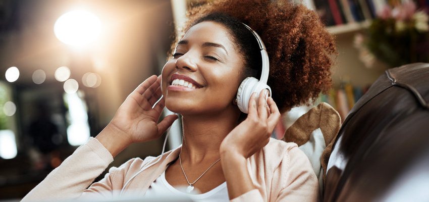 Mulher com fones de ouvido escutando músicas para relaxar
