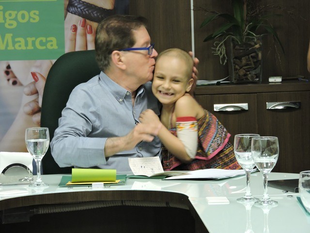 A cliente Maria Clara ganha um abrao do presidente da Unimed Fortaleza, Dr. Joo Borges.