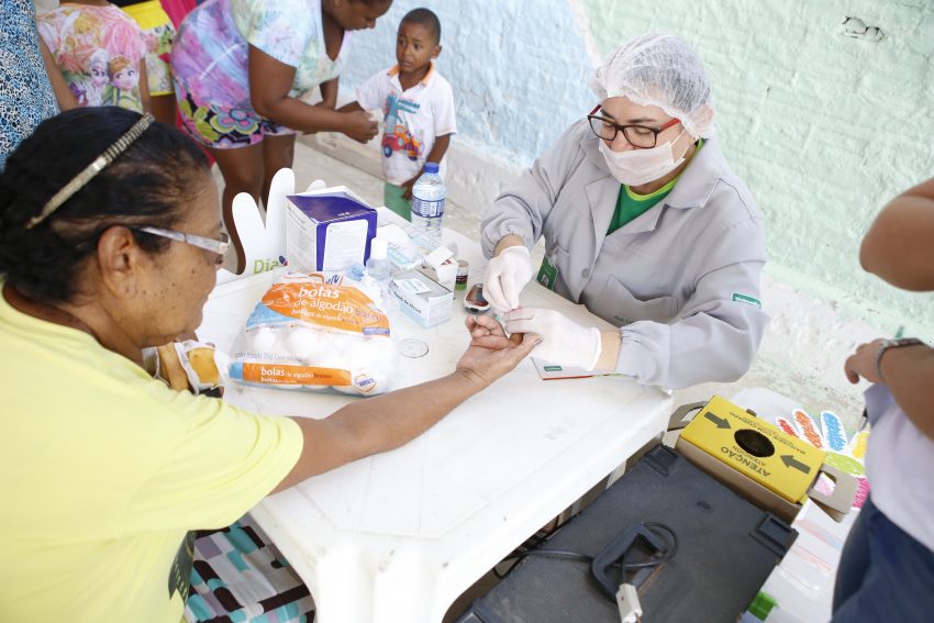 Uma das participantes realizando teste de glicemia no Dia de Cooperar