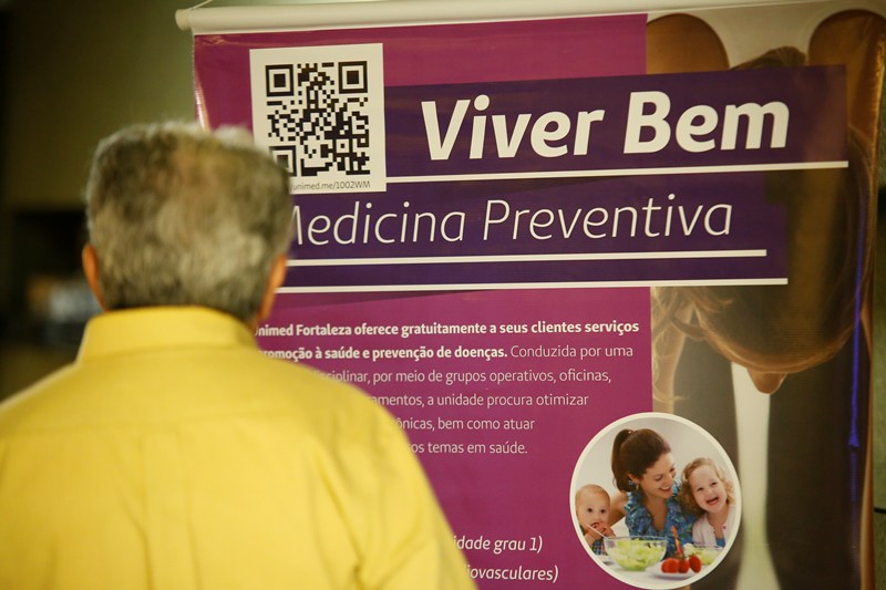 Participante observando um banner da Medicina Preventiva
