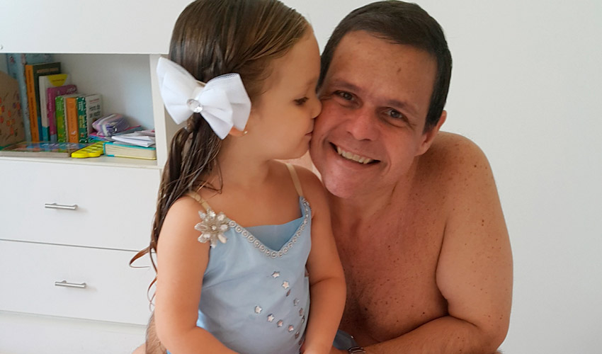 Gilson Gomes e sua filha dando um beijo em sua bochecha