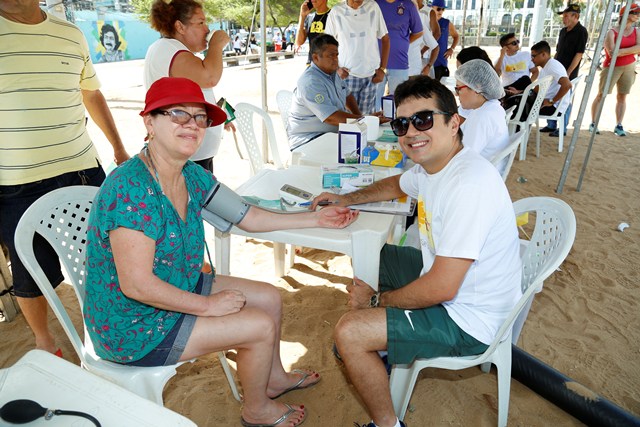 Participante realizando aferição da pressão com um dos colaboradores da Medicina Preventiva