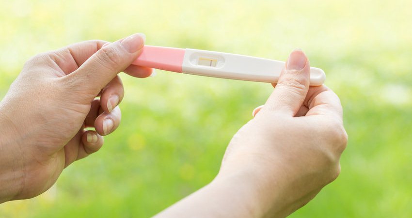 Mulher segurando teste de gravidez negativo 