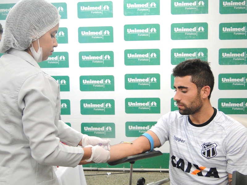 Jogador do Ceará realizando exame de sangue junto da enfermeira do Hospital Regional Unimed