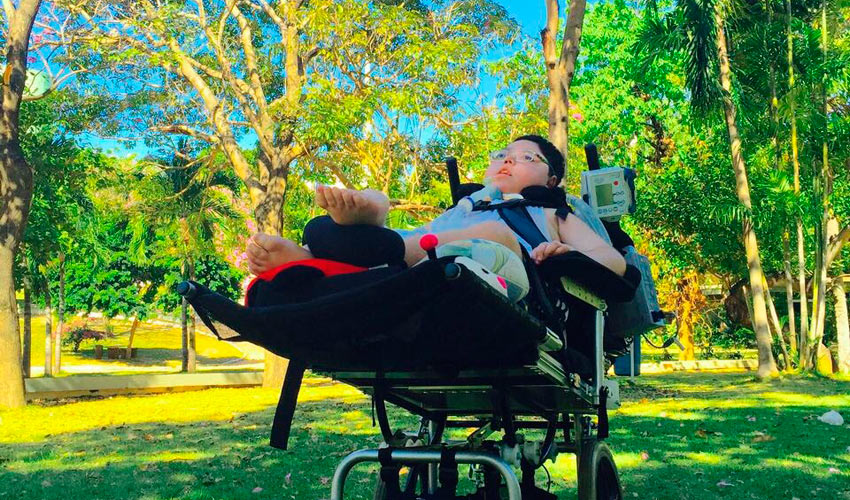 Lucas Braga em sua cadeira de rodas especial ao ar livre