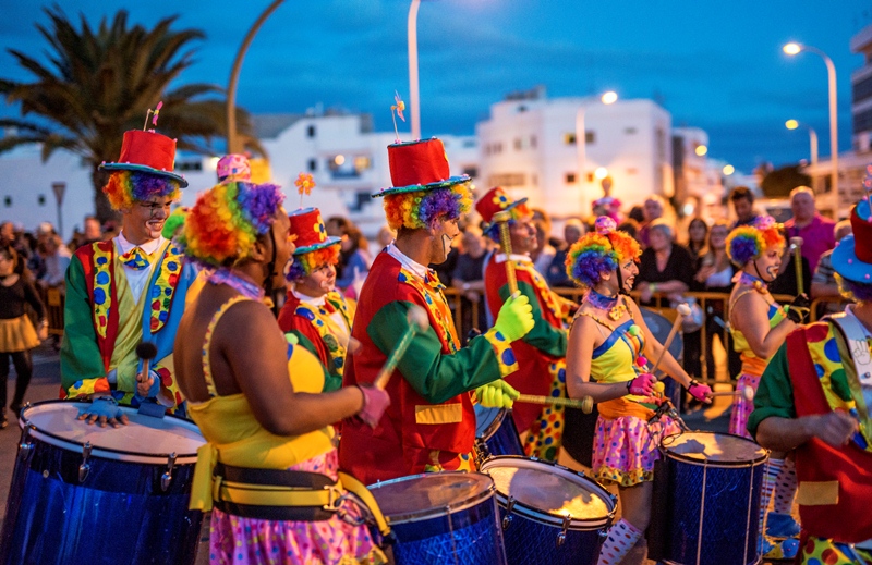 Pessoas fantasiadas de palhao com tambores tocando no Carnaval