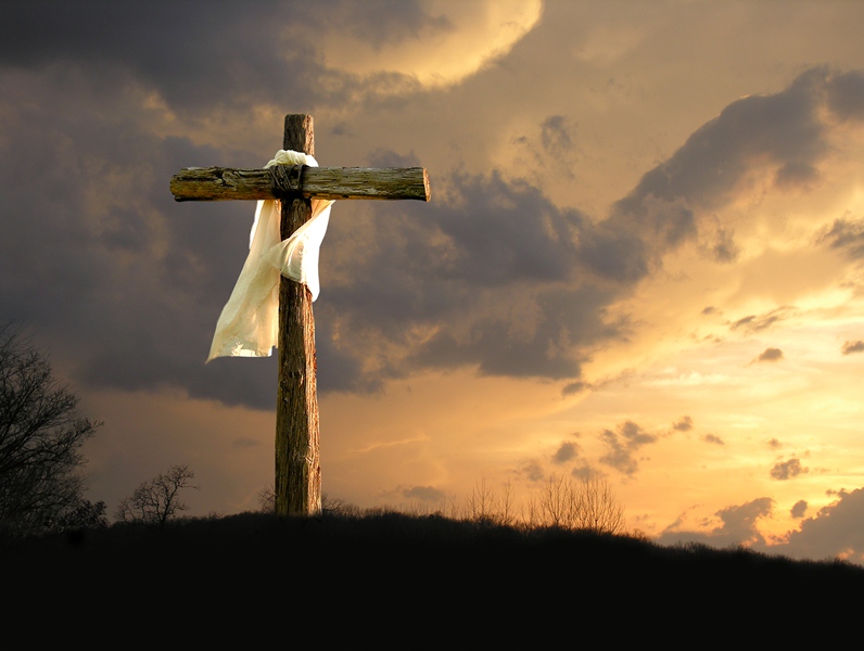 Imagem de uma cruz com um leno em uma colina