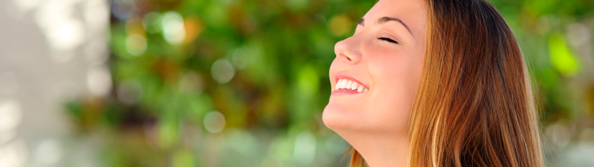 Mulher sorrindo e fazendo respirao profunda, que ajuda quem tem problemas respiratrios