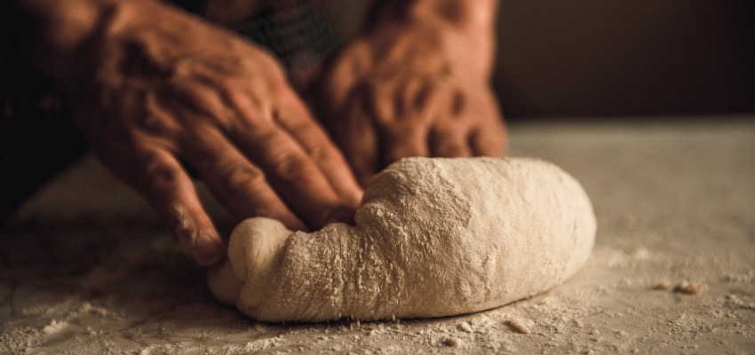 Pessoa preparando a massa de trigo na mesa de farinha de trigo, relacionado  doena celaca ou sensibilidade ao glten