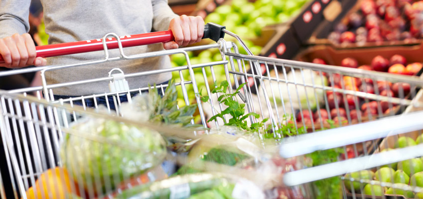 Mulher carregando carrinho de supermercado com alimentos saudveis para desmistificar que  caro ser saudvel