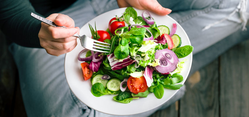 Pessoa segurando um prato com salada bem saudvel ajudando a manter o corpo ideal