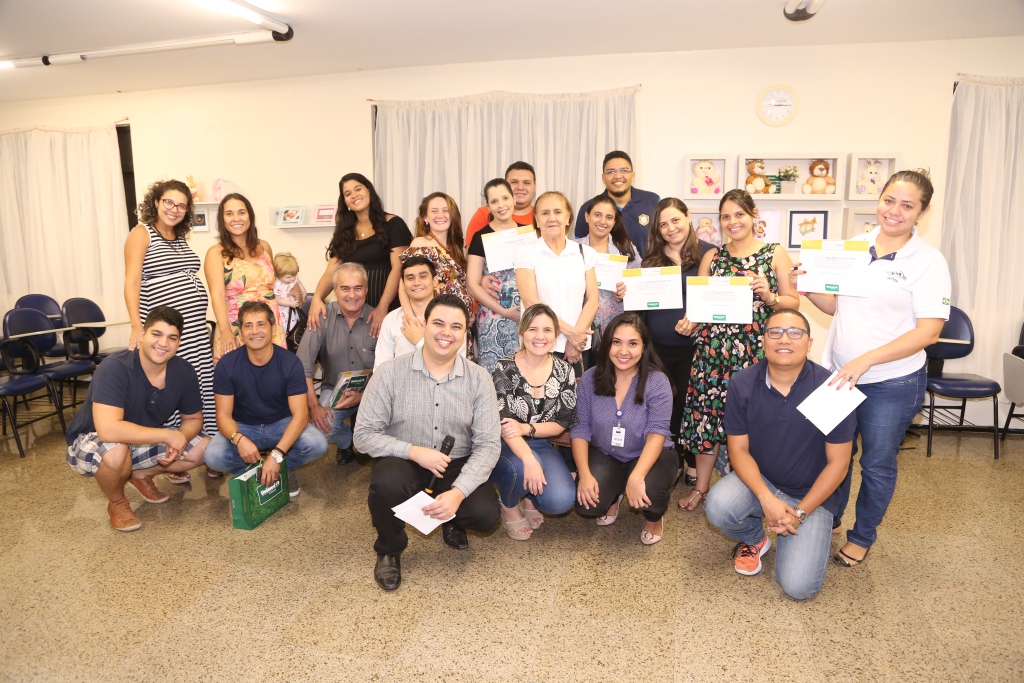 Participantes do Dia de Mama segurando certificados de participao e sorrindo para a foto juntos