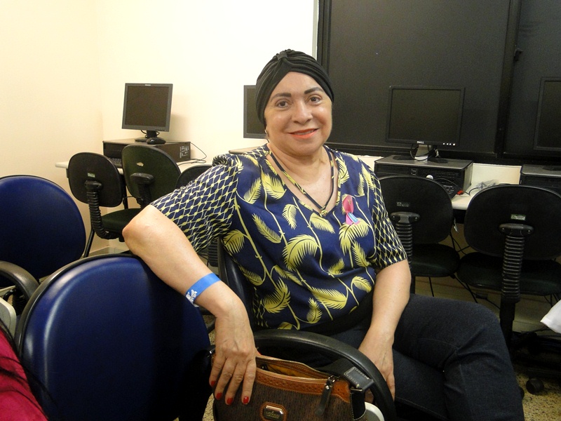 Uma das participantes da palestra e paciente da oncologia do HRU com turbante na cabea sorrindo para a camera