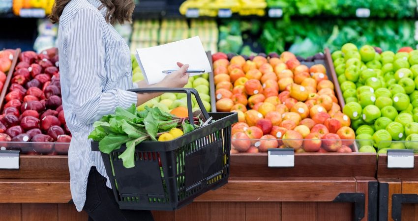 Mulher escolhendo recomendados por nutricionistas no supermercado