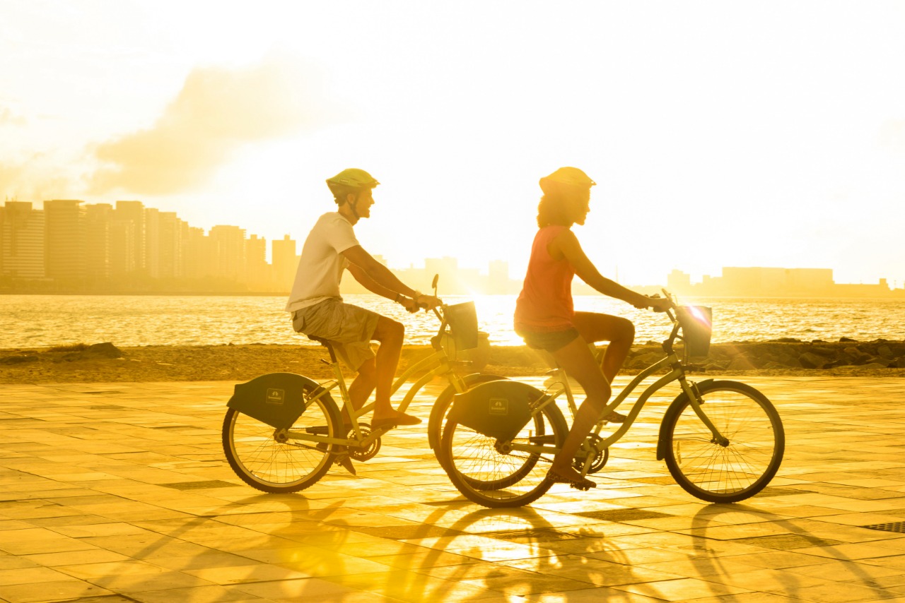 Duas pessoas pedalando na avenida beira mar de Fortaleza