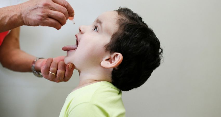 Criana recebendo vacina em gotinha