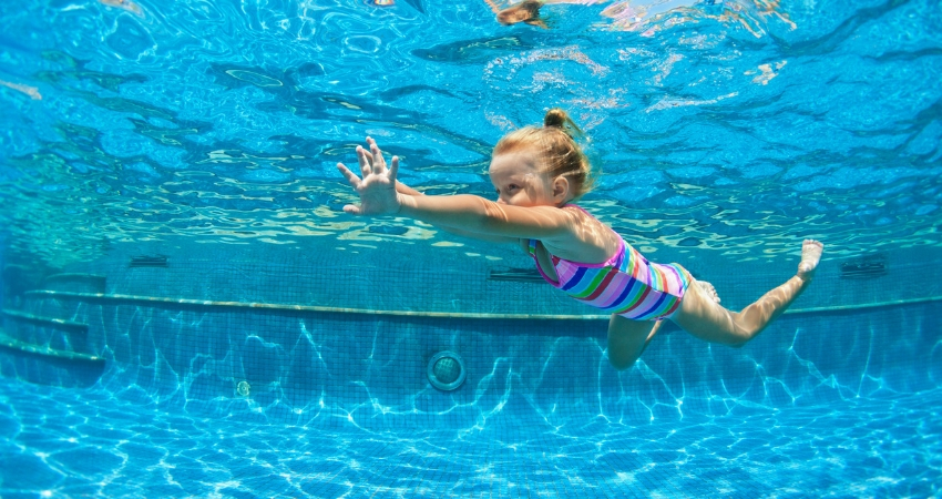 Garotinha nadando em uma grande piscina