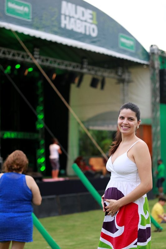 Foto de uma mulher grávida com o palco do evento ao fundo