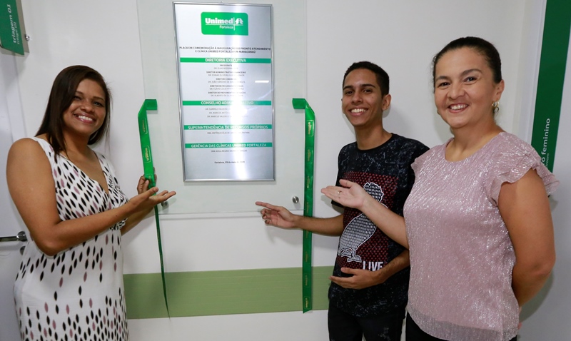 Alguns colaboradores da nova unidade com a placa de inauguração