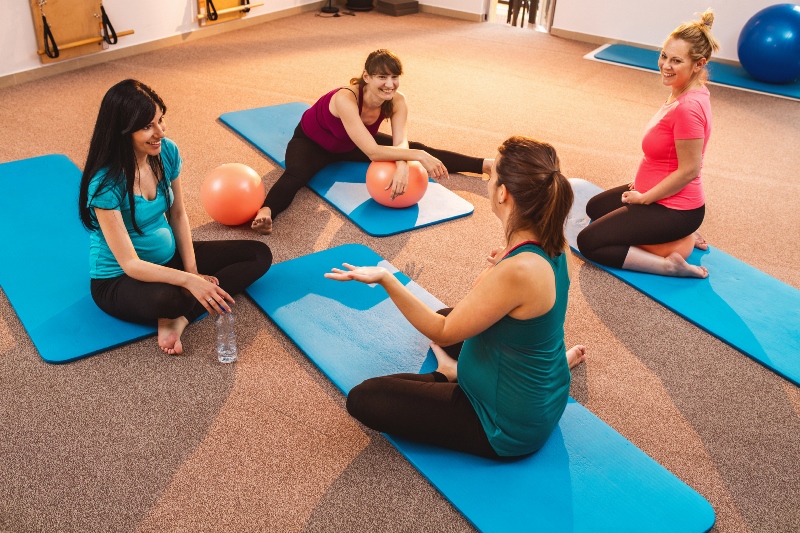 Grvidas juntas realizando exerccios em colchonetes