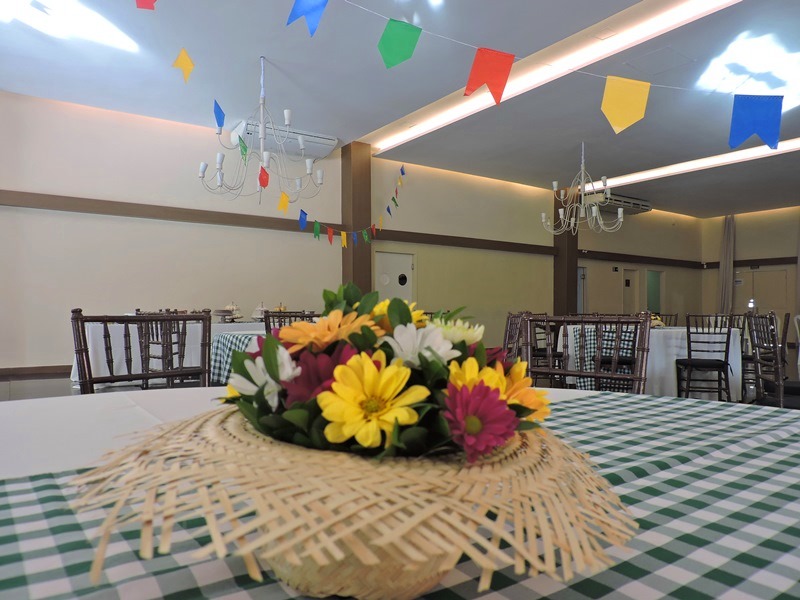 Chapéu de palha com flores em cima de uma mesa no São João do Roda de Vida