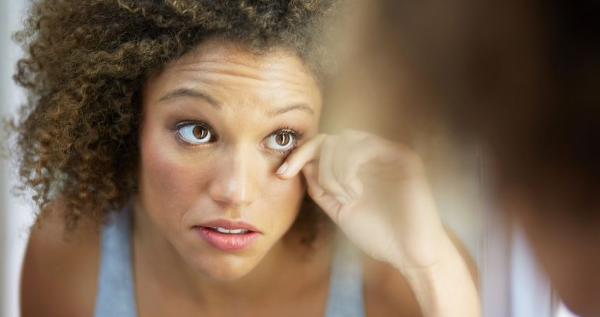 mulher analisando a regio dos olhos para saber se est com anemia.