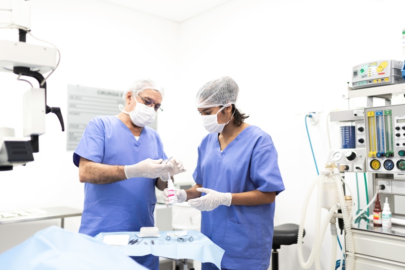 Mdicos com luvas, mscaras e toucas para cabelo em uma sala de hospital