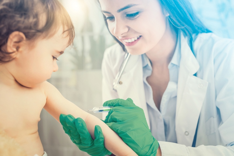 Enfermeira dando vacina em criana divulgando a Unimed Vacinas